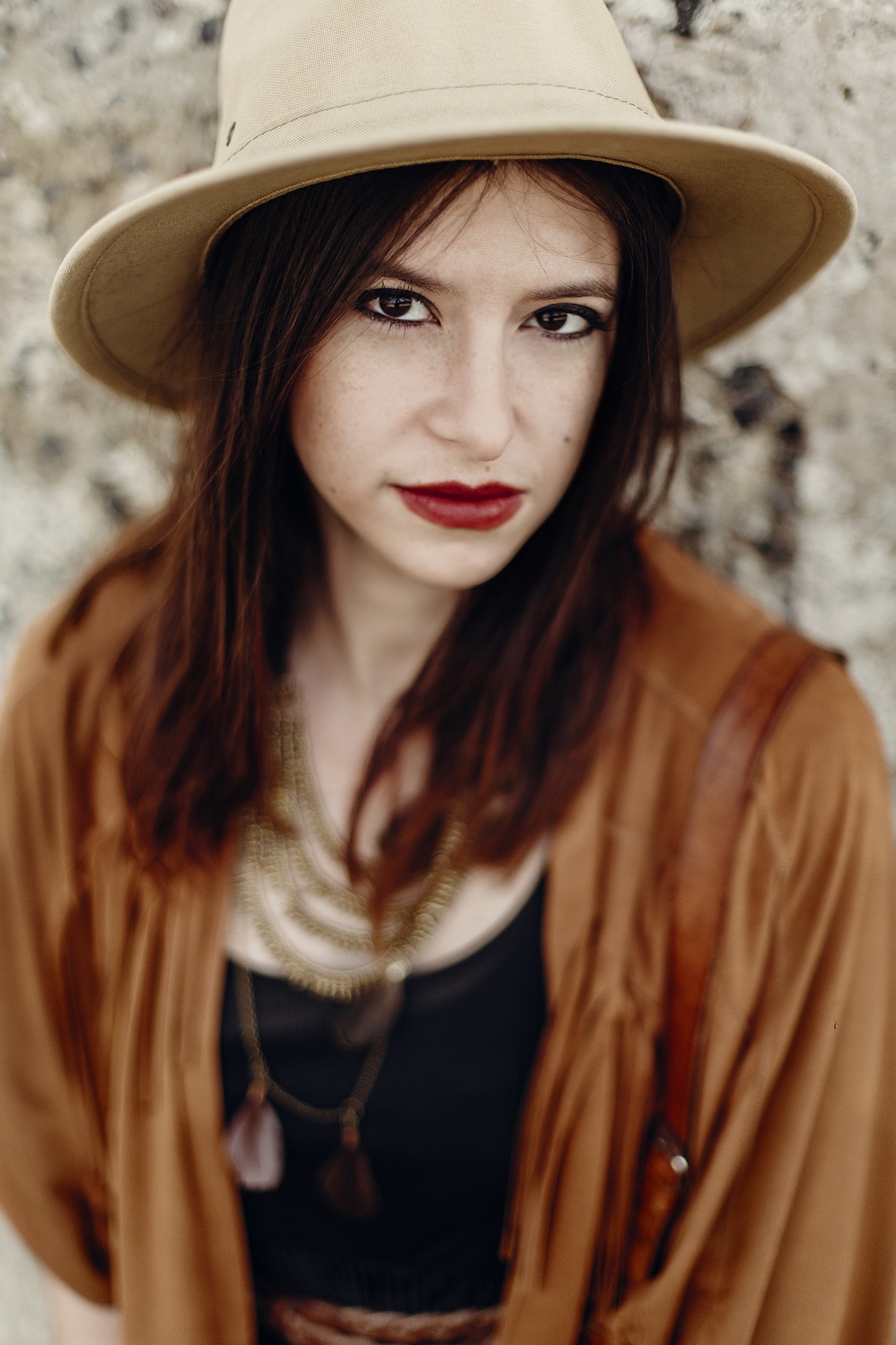 stylish boho woman with jewelry posing at river